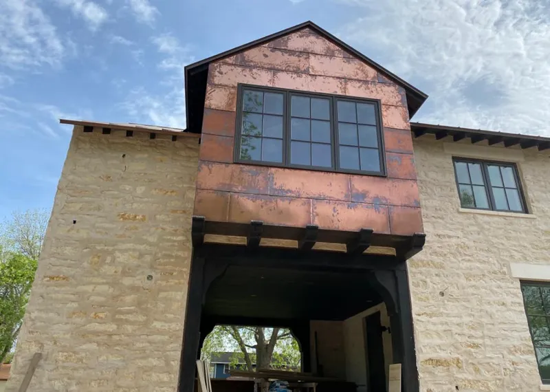 Copper metal panel facade on a stone building for Metal Roof Coating in Granger